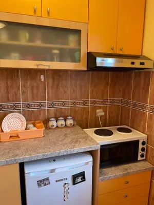 a kitchen with orange cabinets and a stove top oven at Just like home in Vrnjačka Banja