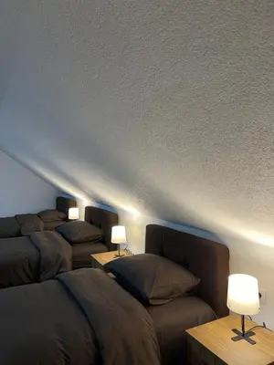 a room with three beds and a couch and lights at Apartmani Ćosić - Kuršumlijska banja in Kursumlijska Banja