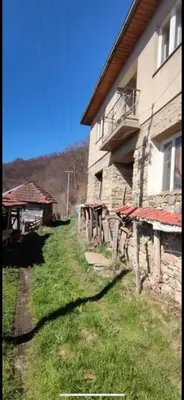 a house with a grass yard next to a building at ANN III in Vlasina Rid