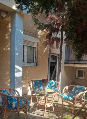 three chairs and a table in front of a building at Mrvica in Vrnjačka Banja