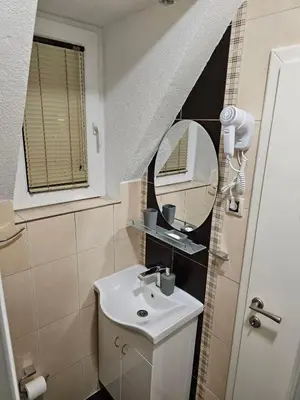 a small bathroom with a sink and a mirror at Apartman Čar11 in Kopaonik