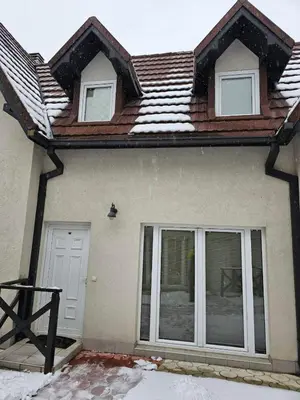 a house with a snow covered roof and windows at Apartman Čar11 in Kopaonik