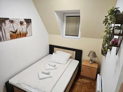 a small room with a bed and a window at Apartman Čar11 in Kopaonik