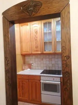 a kitchen with wooden cabinets and a stove at Etno-urban stan na dan in Paraćin