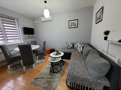 a living room with a grey couch and chairs at Apartman Bubili in Vrnjačka Banja