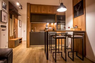 a kitchen with a bar with stools at Pukikop Apartman in Kopaonik