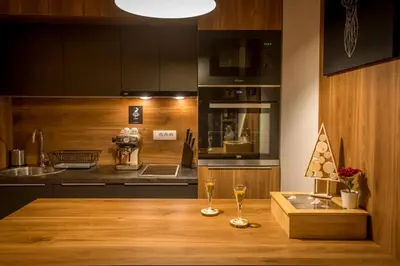 a kitchen with two wine glasses on a wooden table at Pukikop Apartman in Kopaonik