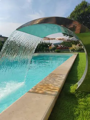 a pool with a water fountain in a park at Pukikop Apartman in Kopaonik
