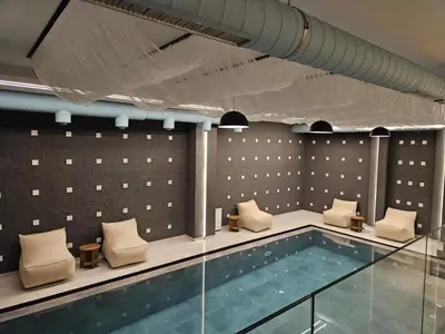 a swimming pool with white chairs and a swimming pool at Pukikop Apartman in Kopaonik
