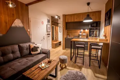 a living room with a couch and a kitchen at Pukikop Apartman in Kopaonik