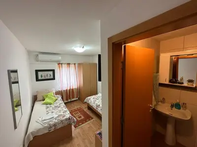 a small room with a bed and a sink at Aparmani Ušće in Trstenik