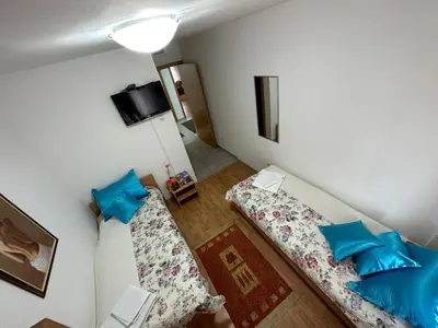 a small room with two beds and blue pillows at Aparmani Ušće in Trstenik