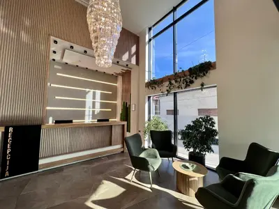 a lobby with chairs and a table and a chandelier at Hotel Zeleni Grad in Soko Banja