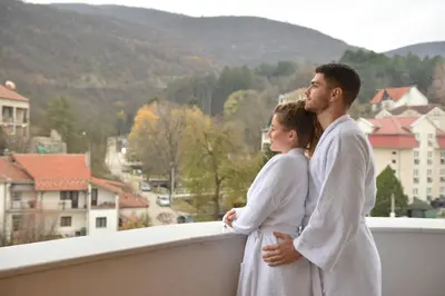 a man and a woman standing on a balcony at Hotel Zeleni Grad in Soko Banja