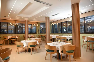 a restaurant with tables and chairs and windows at Hotel Zeleni Grad in Soko Banja
