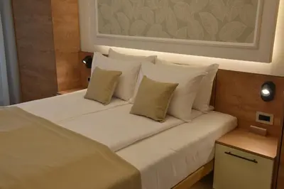 a bed with white pillows in a room at Hotel Zeleni Grad in Soko Banja