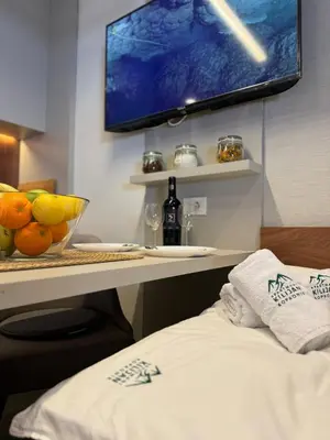a room with a desk with a television and a bed at Apartmani Kilijan Kopaonik in Kopaonik