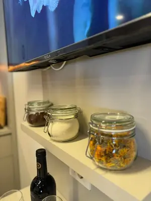 a refrigerator shelf with jars and a bottle of wine at Apartmani Kilijan Kopaonik in Kopaonik