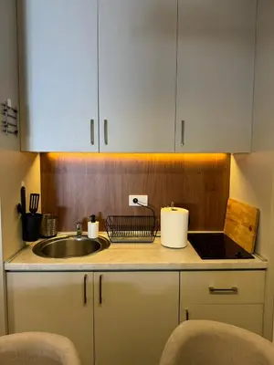 a kitchen with a sink and a counter with chairs at Apartmani Kilijan Kopaonik in Kopaonik
