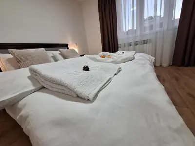 a large white bed with a stuffed animal on it at Relax Lux apartment Nis in Niš