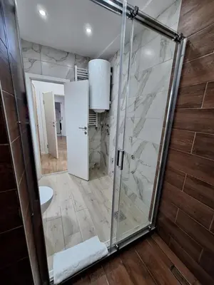 a bathroom with a shower with a glass door at Relax Lux apartment Nis in Niš