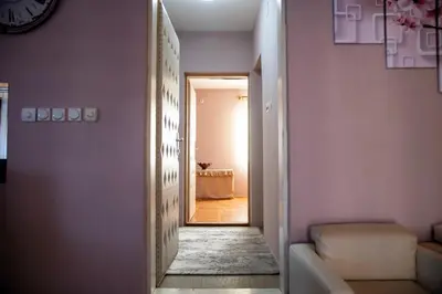 a hallway with a room with pink walls and a door at Apartman Lara in Kuršumlija