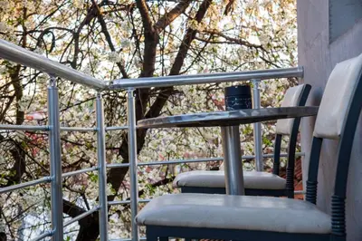 a glass table and two chairs on a balcony at Apartman Lara in Kuršumlija