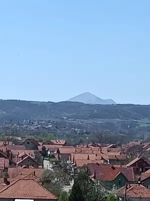 a village with red roofs and mountains in the background at Apartman MIKA in Zaječar