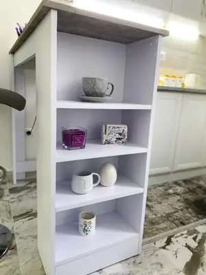 a white shelf with cups and mugs on it at Apartman Amaris in Vrnjačka Banja