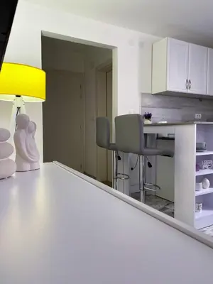 a kitchen with a table with a lamp and chairs at Apartman Amaris in Vrnjačka Banja