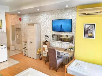 a room with a desk and a tv on a wall at Yellow Diamond in Niš