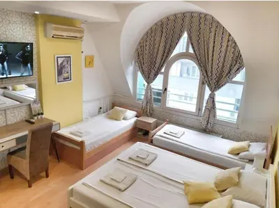 a room with three beds and a desk and a window at Yellow Diamond in Niš