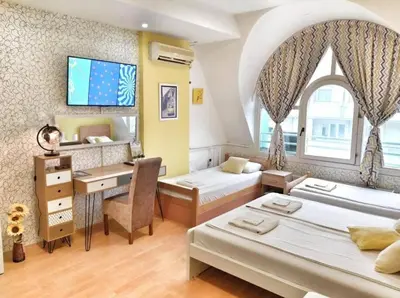 a room with two beds and a desk with a computer at Yellow Diamond in Niš