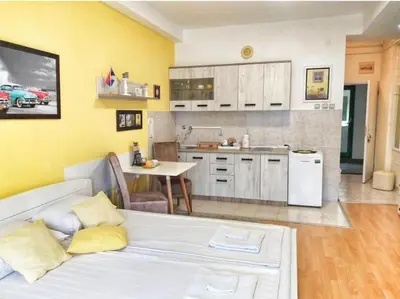 a living room with a white couch and a kitchen at Yellow Diamond in Niš