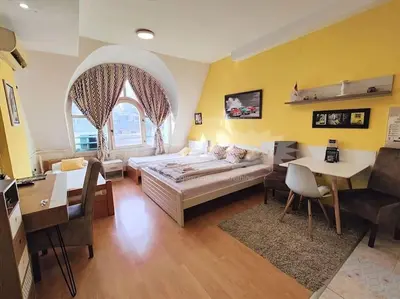 a living room with a large bed and a table at Yellow Diamond in Niš