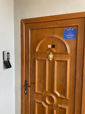 a wooden door with a sign on it at Apartman Dragovic in Kuršumlija