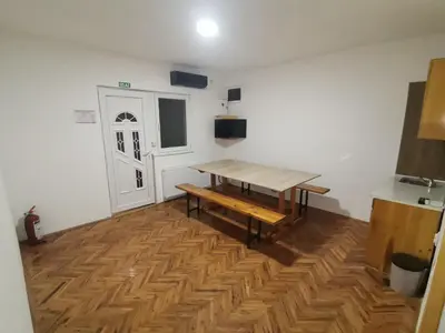 a room with a wooden table and a wooden floor at V&U Sobe in Brzi Brod