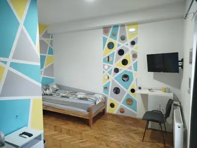 a room with a bed and a wall with a tv at V&U Sobe in Brzi Brod