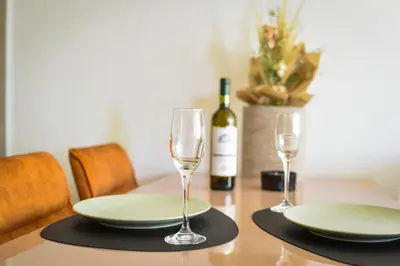 a table with two glasses and a bottle of wine at BAGDALA RESIDENCE APARTMAN in Kruševac
