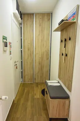a bathroom with a wooden door in a room at BAGDALA RESIDENCE APARTMAN in Kruševac