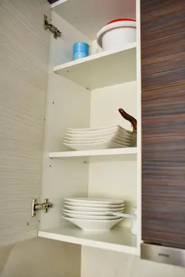 a kitchen with white plates and bowls on shelves at BAGDALA RESIDENCE APARTMAN in Kruševac