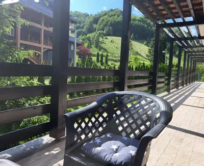 a bench sitting on a porch with a view of a hill at Serendipity Apartment in Brzeće