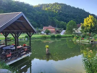a lake with a gazebo and a house at Serendipity Apartment in Brzeće