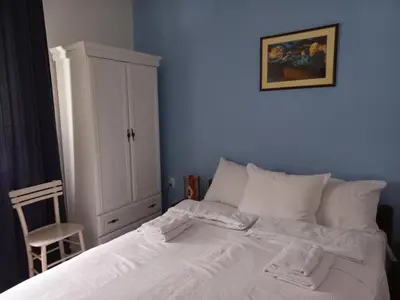a bedroom with a white bed with a blue wall at B&B Vila Babin zub in Balta Berilovac