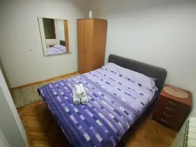 a bedroom with a purple bed with shoes on it at Apartman Mladenovic Center, free parking&wifi in Vranje