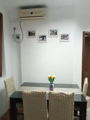 a dining room table with chairs and a vase of flowers at Apartman Mladenovic Center, free parking&wifi in Vranje