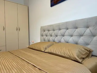 a bed with a large headboard in a bedroom at Milka apartman Sokobanja in Soko Banja