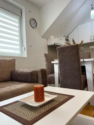 a living room with a table with a candle on it at Milka apartman Sokobanja in Soko Banja