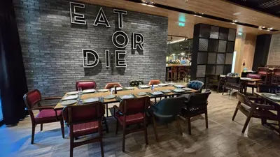 a dining room with a table and chairs and a signeat or die at Hotel Vojvoda Putnik in Vranje