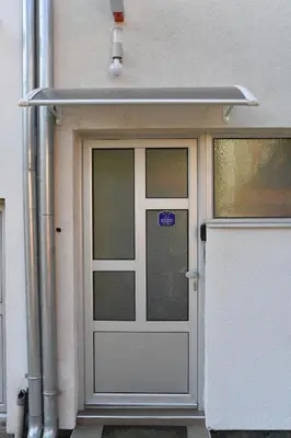 a white garage door with a sign on it at Apartmani Ad fines in Kuršumlija